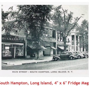 May include: A black and white vintage photograph of Main Street in South Hampton, Long Island, New York. The photo shows a street lined with shops and buildings, with cars parked along the side of the road. The text "HULMAN'S" is visible on the storefront of one of the shops.