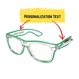 May include: Clear-framed glasses with green trim and arms. The image includes the text "ADD TEXT" on the arms and "PERSONALIZATION TEXT" in a yellow rectangle. The glasses are designed for customization.