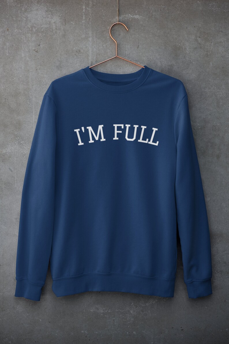K&ouml;nnte beinhalten: Ein marineblauer Pullover mit dem Aufdruck "I'M FULL" in Wei&szlig; auf der Vorderseite.