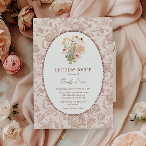 May include: A floral birthday soiree invitation. The invitation features an oval frame with a bouquet of flowers and the text "BIRTHDAY SOIREE" and "Emily Lucas". The invitation is surrounded by pink flowers and fabric.