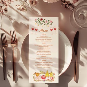 May include: A wedding menu card with a floral design and wine glasses. The menu lists entree, main, dessert, and drinks. The card is on a white table with flowers, plates, and silverware.