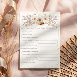 May include: A cream-colored bridal shower game card with floral and book illustrations. The text "How well do you know the bride?" is at the top, with fill-in-the-blank questions below. A decorative fan is in the background.