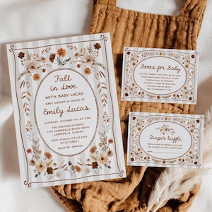 May include: Baby shower stationery set with floral details. The invitation reads "Fall in Love with Baby Lucas" and includes event details. The inserts include "Books for Baby" and "Diaper Raffle". The design features brown and beige tones.