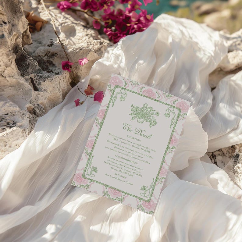 May include: A rectangular wedding invitation card featuring a light green decorative border with floral motifs and pink rose illustrations. The text includes The Details, Reception, Accommodation, and Registry with printed event information.