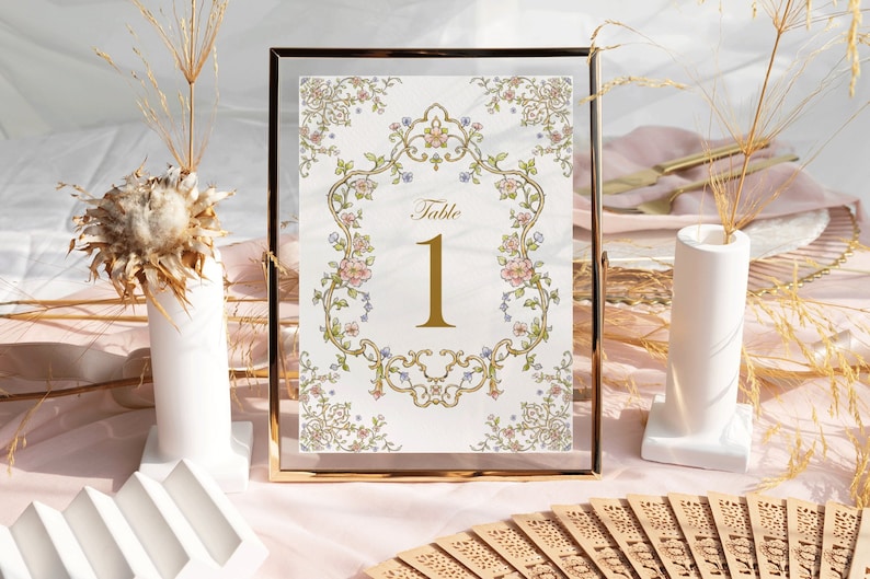 May include: A gold-framed table number card with a floral design and the text "Table 1" in gold lettering.