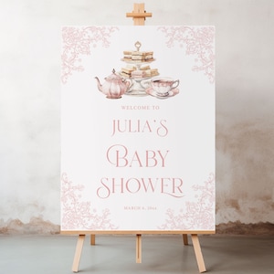 May include: A white sign with pink floral borders and a watercolor illustration of a teapot, teacups, and a tiered cake stand with sandwiches. The sign reads "Welcome to Julia's Baby Shower March 8, 2024".