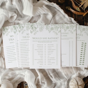 May include: Five printable wedding game cards with a green floral design. The cards include "We Traveled, Why I...", "The Guessing Game", "Would She Rather?", "Wedding Game", and "He Said, She Said".