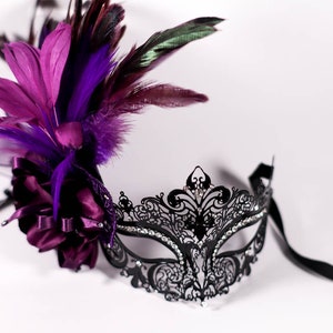 masque de mascarade, masque de mascarade avec une fleur violette, une pierre précieuse blanche et des plumes noires/violettes, masque en métal découpé au laser, cristaux noirs et blancs