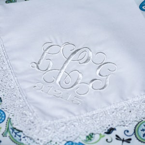 May include: White handkerchief with a lace border and embroidered initials "L.B.G." and the date "9.12.15".