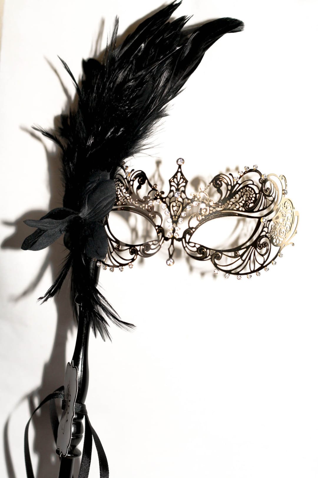 Gold Masquerade Mask With a Stick Mask Handle With Black Feathers