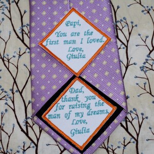 May include: Two diamond-shaped fabric patches with orange borders and white backgrounds. The top patch reads "Papi, You are the first man I loved. Love, Giulia". The bottom patch reads "Dad, thank you for raising the man of my dreams. Love, Giulia".