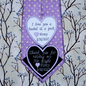 Pode incluir: Uma gravata roxa com bolinhas brancas e dois patches em forma de coração. O patch superior é branco com texto preto que diz "I love you a bushel & a peck Esmy 3/26/2017". O patch inferior é preto com texto branco que diz "Thank you for raising my Mr Right Esmy 3/26/2017".