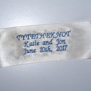 Può includere: Nastro di raso bianco con testo ricamato in blu che recita "TYTETHKNOT Katie e Jon June 10th, 2017".