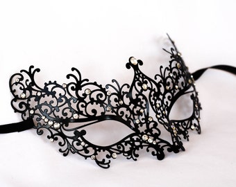 Può includere: Maschera da ballo nera con un design in pizzo intricato e strass trasparenti.