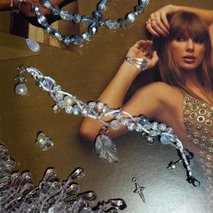 Puede incluir: Una colecci&oacute;n de joyas de cuentas transparentes e iridiscentes. Las piezas incluyen una pulsera que deletrea "CHERISH", un collar y un anillo. La pulsera presenta un dije de hoja y un dije de estrella. Las joyas est&aacute;n sobre un fondo dorado.