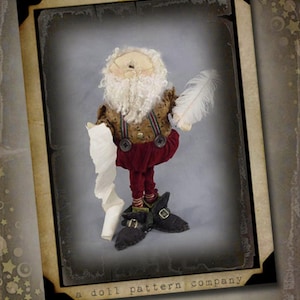 May include: A handcrafted doll dressed as Santa Claus, holding a feather and a scroll. The doll has a white beard, glasses, and is wearing a brown jacket, red pants, and black shoes. The doll is framed with a vintage-style border.