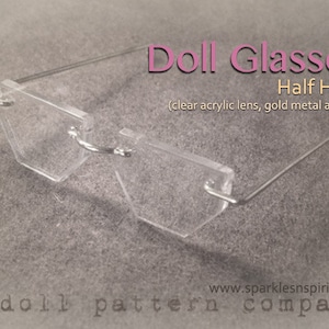May include: Clear acrylic doll glasses with a half-hexagonal shape and gold metal arms. The text on the image reads "Doll Glasses Half Hex (clear acrylic lens, gold metal arms)" and "www.sparklesnspirit.com a doll pattern company."