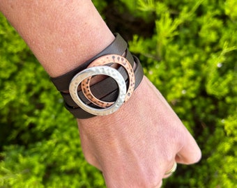 Nordic reindeer leather bracelet with a magnetic clasp and two hammered large circles, copper and silver. It wraps around wrist three times.