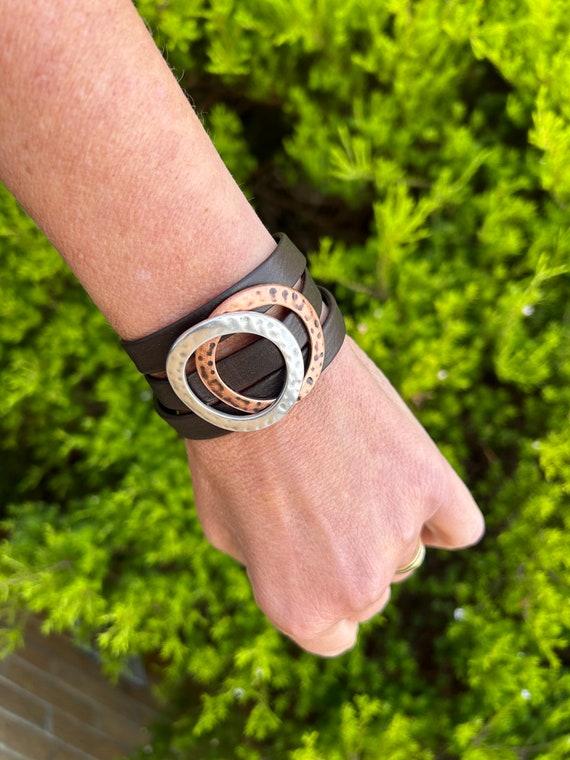 Nordic reindeer leather bracelet with a magnetic clasp and two hammered large circles, copper and silver. It wraps around wrist three times.