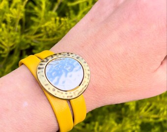Wrap around reindeer leather bracelet with a magnetic clasp. Made with hammered gold ring and silver round sliders.