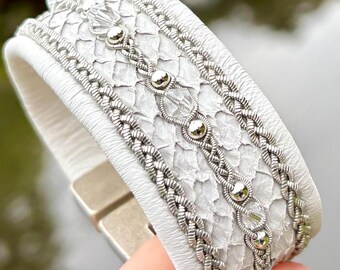 Sami inspired cuffs with reindeer and salmon leather. Made with three braids of pewter and 3mm sterling silver beads and European crystals.