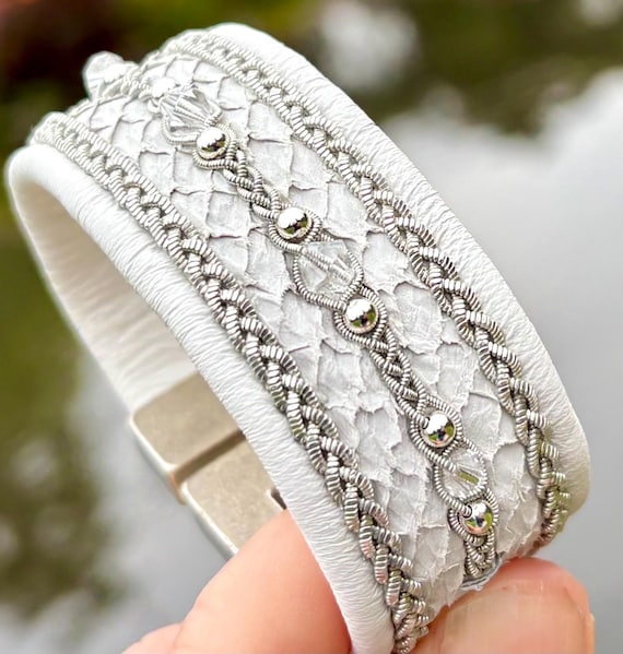 Sami inspired cuffs with reindeer and salmon leather. Made with three braids of pewter and 3mm sterling silver beads and European crystals.