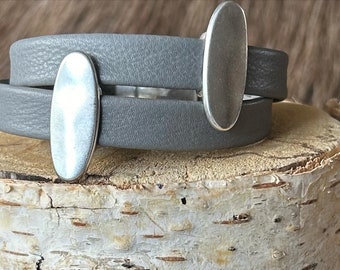 Wrap around Nordic reindeer leather bracelet with a magnetic clasp and two oval slightly hammered silver sliders.