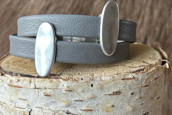 Wrap around Nordic reindeer leather bracelet with a magnetic clasp and two oval slightly hammered silver sliders.