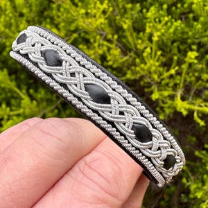 Nordic traditional Sami leather bracelet with borders of silver and pewter braiding. Unisex wristband accessory made to order.