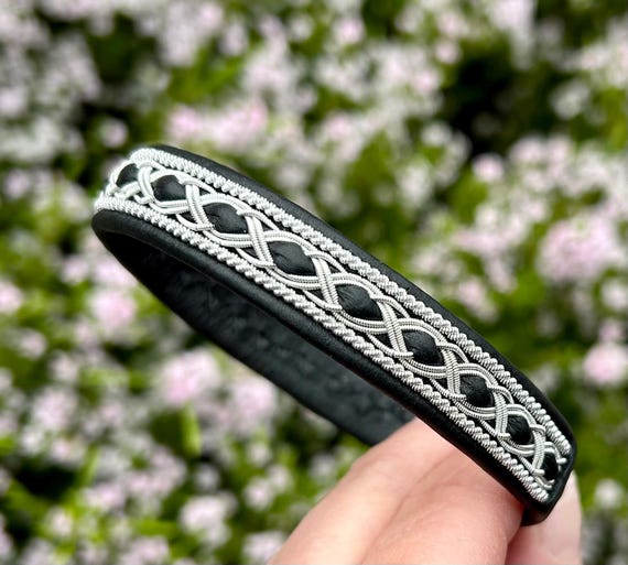 Nordic traditional Sami leather bracelet with borders of silver and pewter braiding. Unisex wristband accessory.