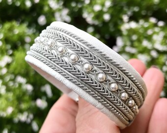 Nordic Sami inspired reindeer leather cuff bracelet, with traditional pewter braiding and pearl beads.