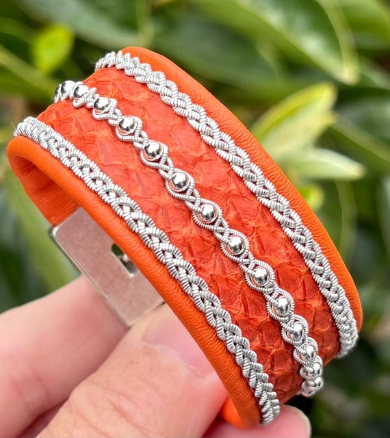 Sami inspired cuffs with reindeer and salmon leather combination. Made with three braids of pewter and sterling silver beads.
