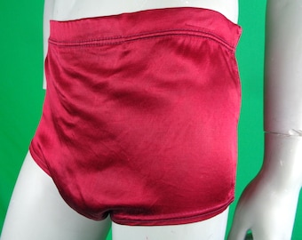 May include: High-waisted briefs in a deep, solid red color with a smooth, satin-like finish. The garment features a wide, elasticized waistband and clean, stitched seams along the edges, providing a simple and uniform appearance throughout.