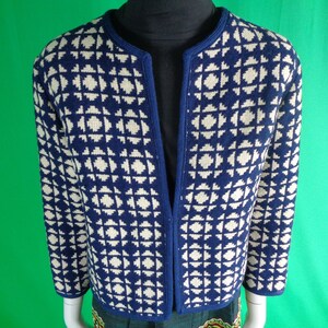 Może przedstawiać: Niebieski i biały kardigan w geometryczny wzór, z dekoltem w kształcie litery V i długimi rękawami.