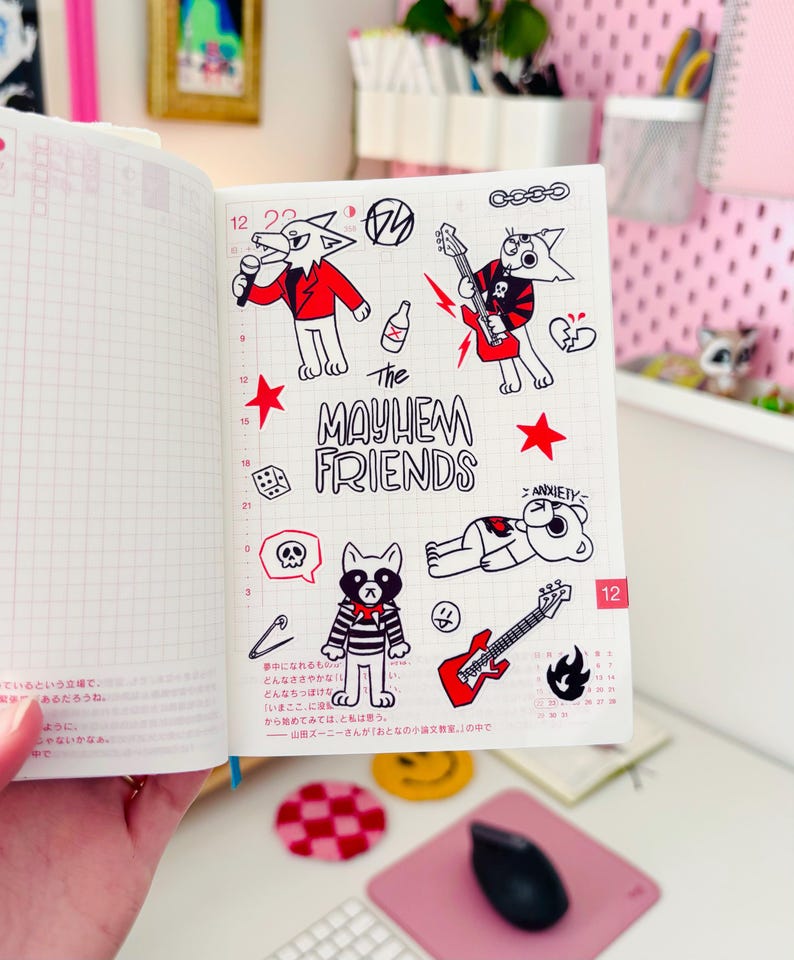 May include: A page from a planner with black and white illustrations of cartoon animals. The animals are playing music and have a punk rock aesthetic. The text "The Mayhem Friends" is written in black and white.