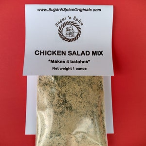 May include: A white pouch with a label that reads "Sugar 'n Spice" and "Chicken Salad Mix" with the text "*Makes 4 batches*" and "Net weight 1 ounce". The pouch contains a beige powder mix.