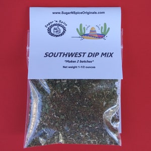 May include: A white resealable pouch with a blue label that reads "Sugar 'n Spice" and "Southwest Dip Mix" with a cactus and sombrero graphic. The label also states "Makes 2 batches" and "Net weight 1-1/2 ounces". The pouch contains a brown and green spice mix.