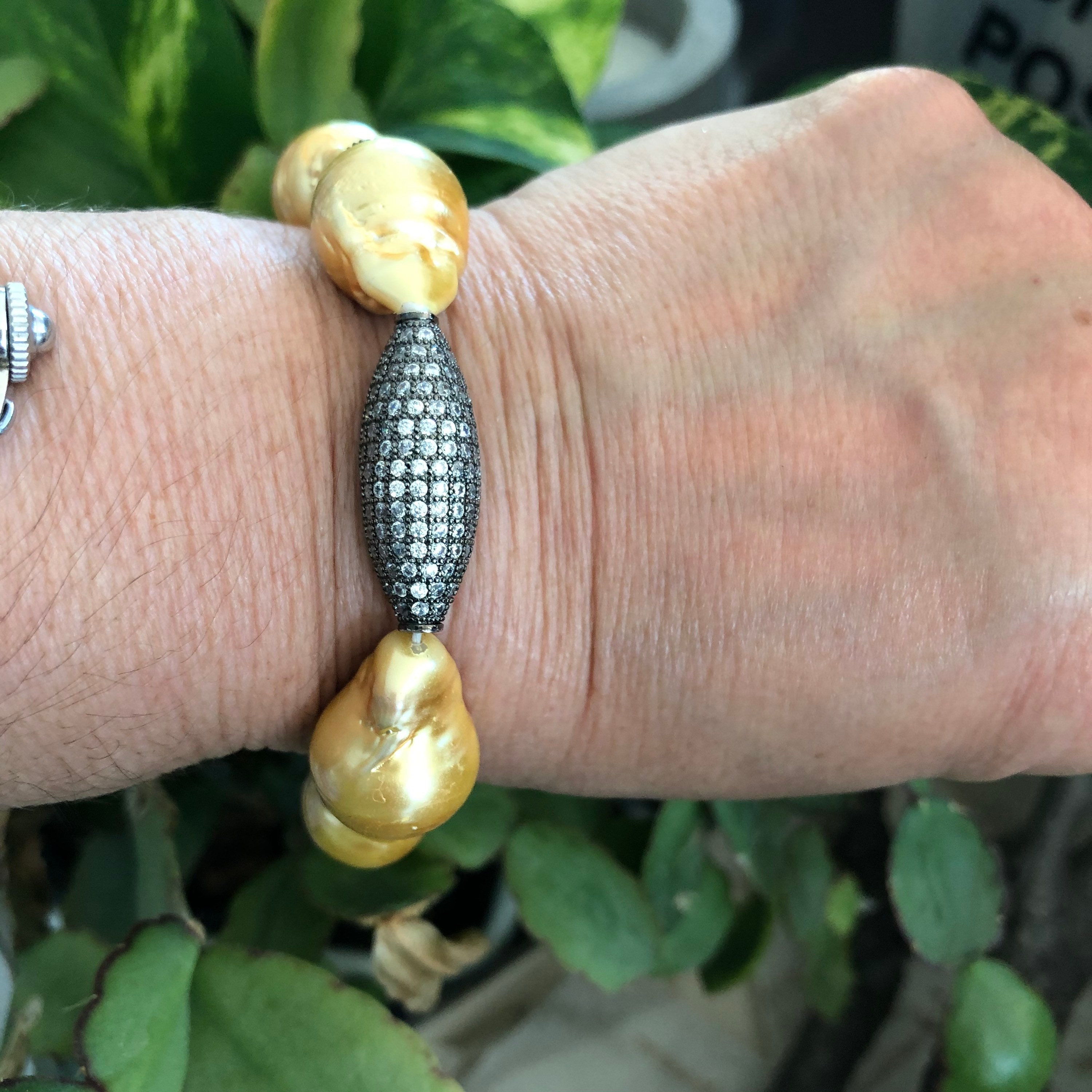 Bracciale elastico con perle barocche in oro metallizzato, accento con barra pavé - Italia