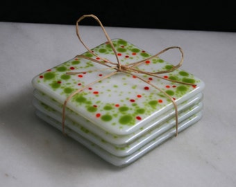 Handmade fused art glass coasters. 'Cosmic Horizons - Spring blossoms'  Green, red and orange on a white base. Choose a pair or a set of 4.