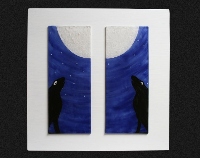 Fused glass painting 'Moon Gazing Hares' Diptych. Two hares silhouetted against a starry nigh sky gazing at the moon, set on a white frame.