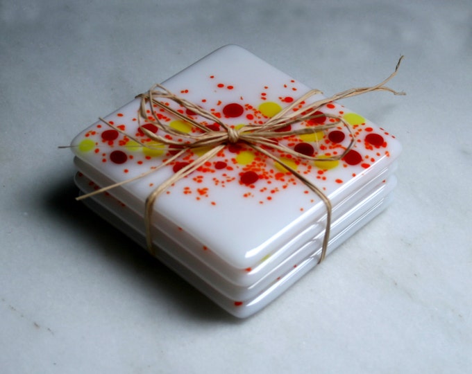 Handmade fused art glass coasters. 'Cosmos - Salamander'  Vibrant red, yellow and orange on a white base. Choose a pair or a set of 4.