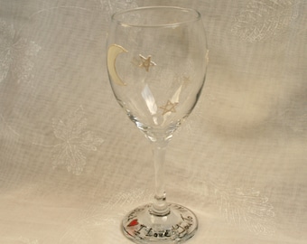 Moon And Back. An exclusive hand painted wine glass featuring a moon and stars and around the base the words 'I love you to the Moon & Back'
