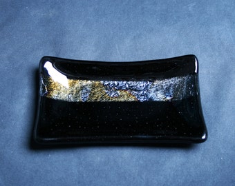 Seismic - Hand made fused glass soap / trinket / small sushi dish. A swathe of shimmering iridescent finish in a black base.