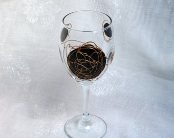 Galaxy - Black and Gold - An exclusive design, hand painted, wine glass featuring black 'planets' swirled with raised gold 'orbit trails'