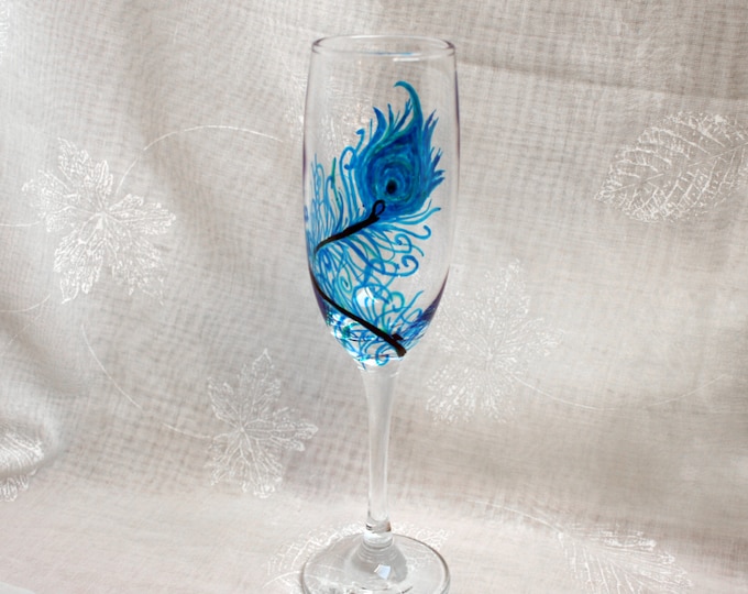 Peacock - An exclusive design, hand painted, large peacock feather encircling the bowl of a Champagne glass. In shades of blue & green.