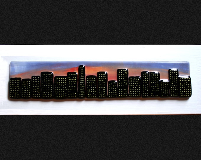 Fused glass painting 'Sunset city'.  Cityscape on a hand painted sunset background, set on a white frame. 34 x 10cm (13.5 x 4")