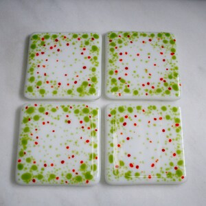 Handmade fused art glass coasters. 'Cosmic Horizons Spring blossoms' Green, red and orange on a white base. Choose a pair or a set of 4. image 2