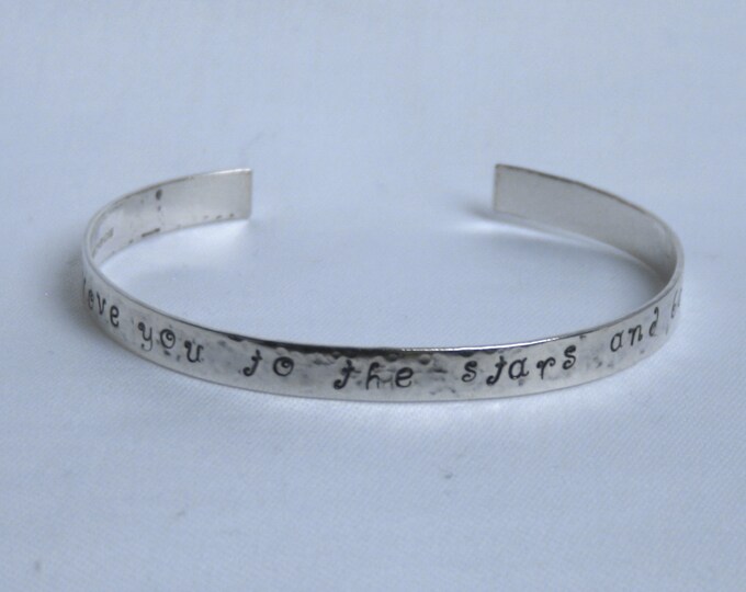 Traditionally hand made cuff bracelet. 'I love you to the Stars and Back'  Hammered finish with words and stars. Fully UK Hallmarked Silver.