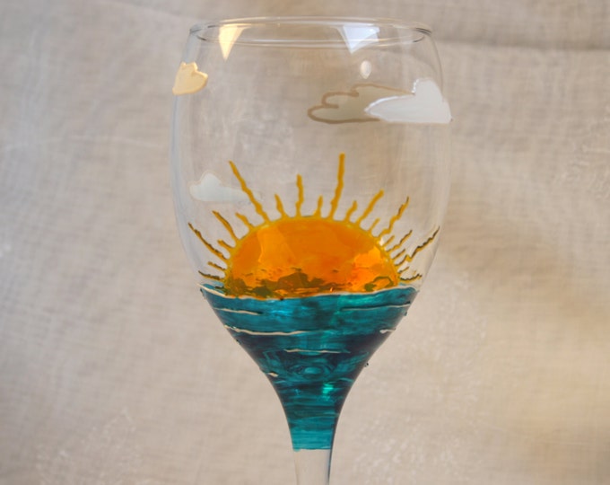 Sunshine. Exclusive design, hand painted, wine glass featuring a rising sun, the sea, clouds & around the base the words You are my Sunshine