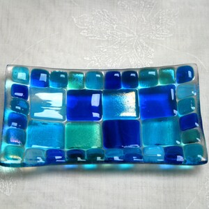 May include: A rectangular glass dish with a mosaic design made of blue, turquoise, and clear glass tiles.